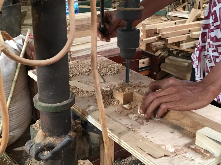 Drill press set up over a workpiece on the bench