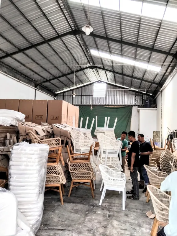 Stacked cardboard cartons and chairs in the workshop store